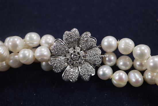 A triple strand freshwater? pearl necklace with white gold and diamond cluster set clasp, 68cm.